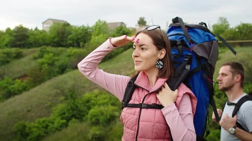 Woman Shielding Eyes While Hiking with Man