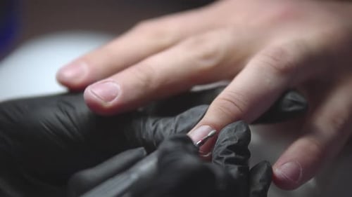 Manicurist Doing Man's Manicure Using Small Drilling Device Cleaning Out Cuticle Zone