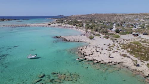 Aerial drone video of yacht anchored in volcanic exotic island bay with crystal clear turquoise sea