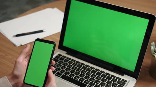 Young Caucasian Woman Using Laptop and Mobile Phone with Green Screen, Freelance and Remote Working