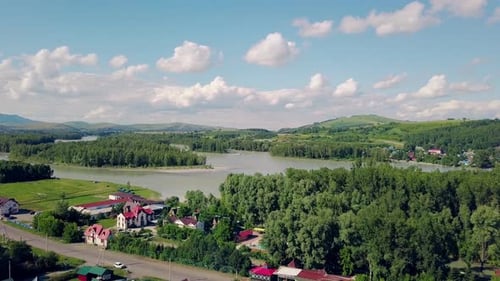 Aerial Shot: Top View of the Tourist City, Mountains, Pine and Deciduous Forest, Mountain River