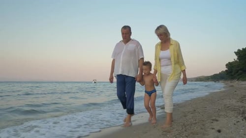 Grandparents and Grandchild Walking on the Beach