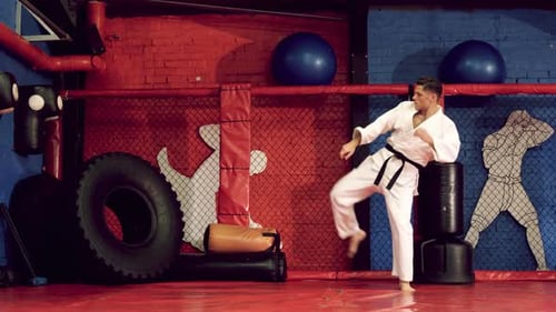 Man Practicing Martial Arts Kicking in Gym