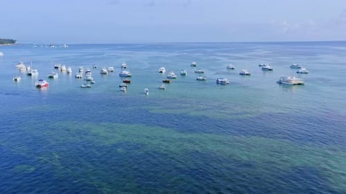 Moored boats on turquoise crystalline sea water of Dominican Republic. Aerial view