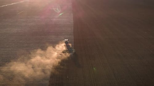 Aerial View Modern Red Tractor on the Agricultural Field on Sunset Time. Tractor Plowing Land and