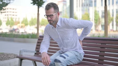 Man Sitting on Bench With Back Pain