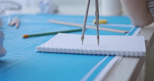 Drawing Compass Designs a Circle on a Blueprint