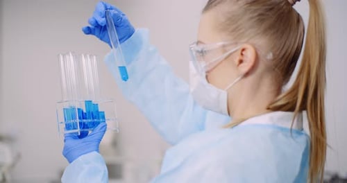 Woman Inspecting Test Tube in Bright Lab