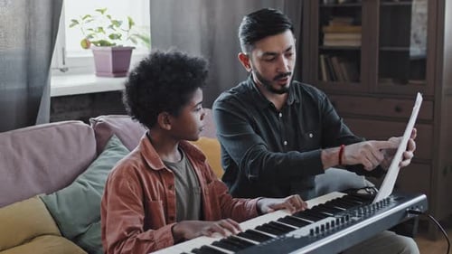 Child Receives Piano Lesson at Home from Adult
