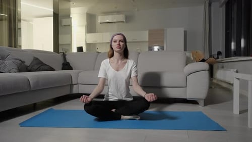 Woman Meditating on Yoga Mat in Apartment