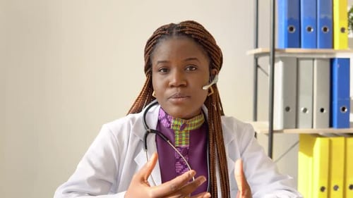 Young African American Woman Doctor Having Chat or Consultation on Laptop