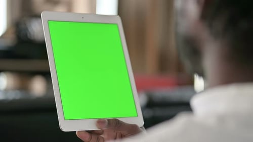 Rear View of African Man Using Tablet with Chroma Key Screen