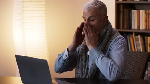 Man Working at Desk at Home Wearing Scarf