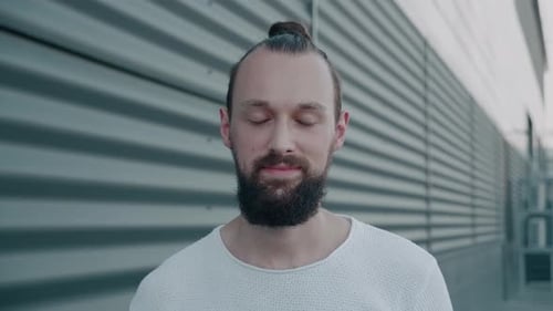 Smiling Man With Beard and Hair Bun Close Up