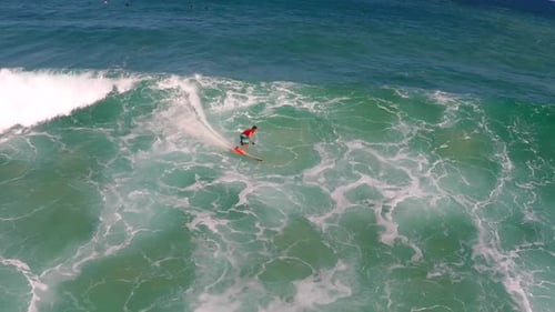 Aerial view of a man sup stand-up paddleboard surfing in Hawaii