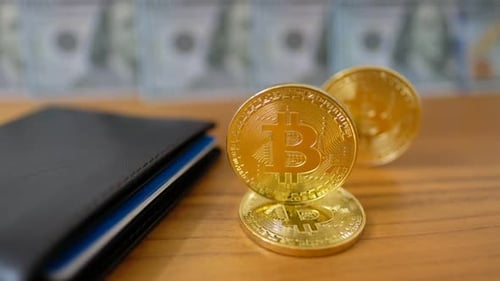 Pièce Bitcoin en or BTC Rotation, torsion, tourbillonnement, rotation et tombe sur la table avec des dollars. Lent