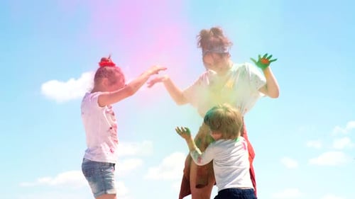 Woman and Children Celebrate with Colorful Powder