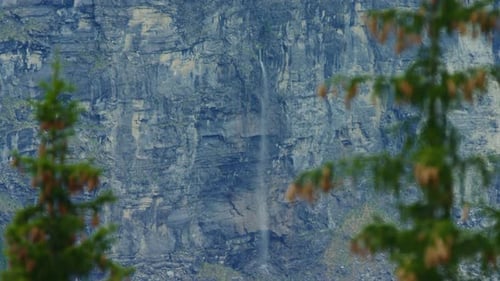 Une énorme cascade jaillit du milieu d'une falaise