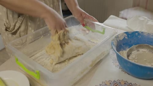 Closeup Shot Of Female Hands Of Baker Kneading Dough In Flour On Wooden Board On Table In Bakery
