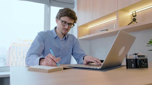 Young Adult Working on Laptop at Desk