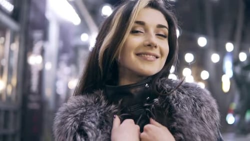 Young Beautiful Pretty Woman Smiling at City Street in the Night Against Evening Lights