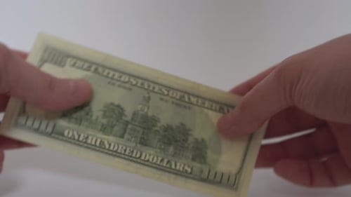 Hands Present Hundred Dollar Bill