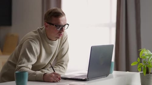 Young Adult Working on Laptop at Desk