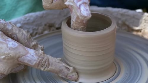 Les mains de potier travaillent avec de l'argile sur un tour de potier. Ralenti