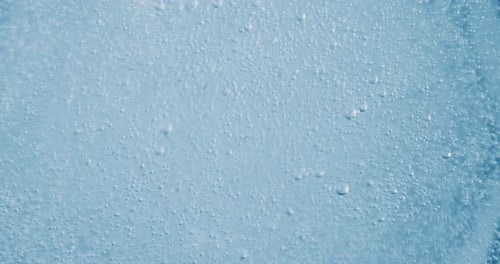 Bubbles Rising in Light Blue Liquid