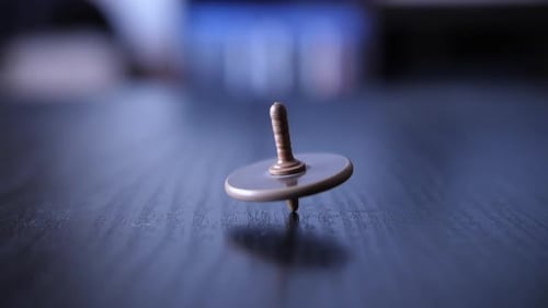 Spinning Top Rotating on Wood Surface