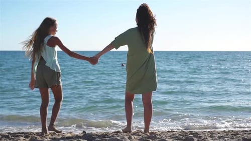 Beautiful Mother and Daughter on the Beach Enjoying Summer Vacation
