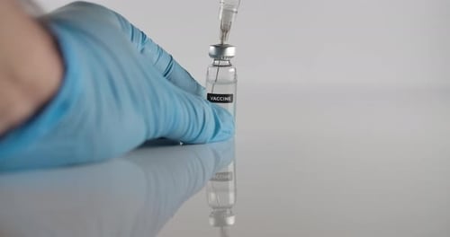 Extracting Vaccine From Vial With Needle Close Up