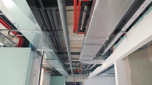 Pipes and Ventilation on the Ceiling of the Building Corridor