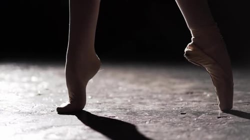 Female Foot Standing in Spotlight on Black Background in Studio