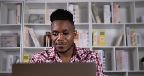 Young Man Works at Laptop in Home Office