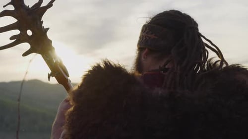 Homem com dreadlocks e capa de pele joga Tovshuur no vale