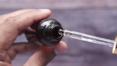 Drop Falls From a Pipette Into a Cosmetic Bottle