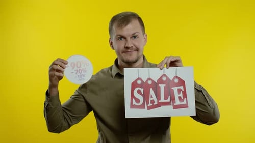 Man Holding Sale and Discount Signs