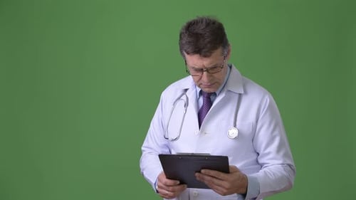 Mature Handsome Man Doctor Against Green Background