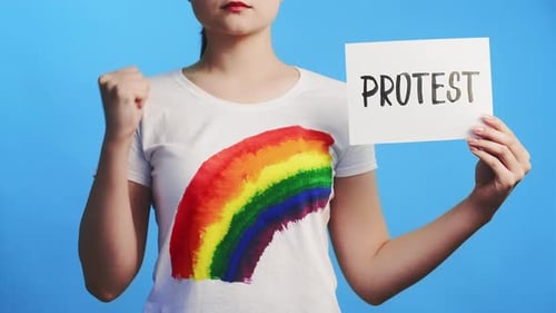 Woman Holds Protest Sign with Rainbow Shirt