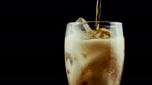 Pouring Fizzy Drink into Glass with Ice