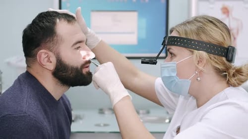 Doctor Examining Patient's Nose in Medical Office