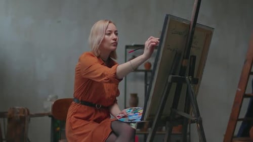 Artist Painting Picture on Canvas with Oil Paints in Workshop