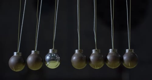 Newtons Cradle Balls in Motion with Hand