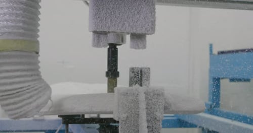 Surfboard being shaped by a machine in a workshop