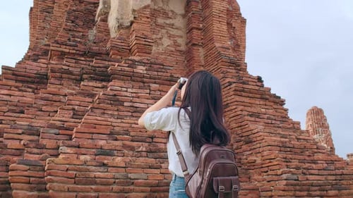 Asian woman using camera for take a picture while spending holiday trip at Ayutthaya,