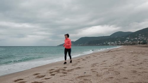 Fitness woman is exercising outdoor, running on beach with seascape background