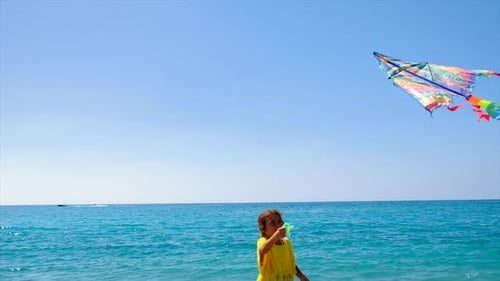 Girl Plays with Kite on Sunny Beach