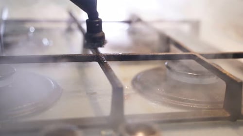 Stove Top Being Cleaned with Steam Nozzle