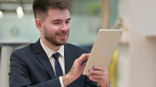 Young Adult Man Using Tablet Indoors